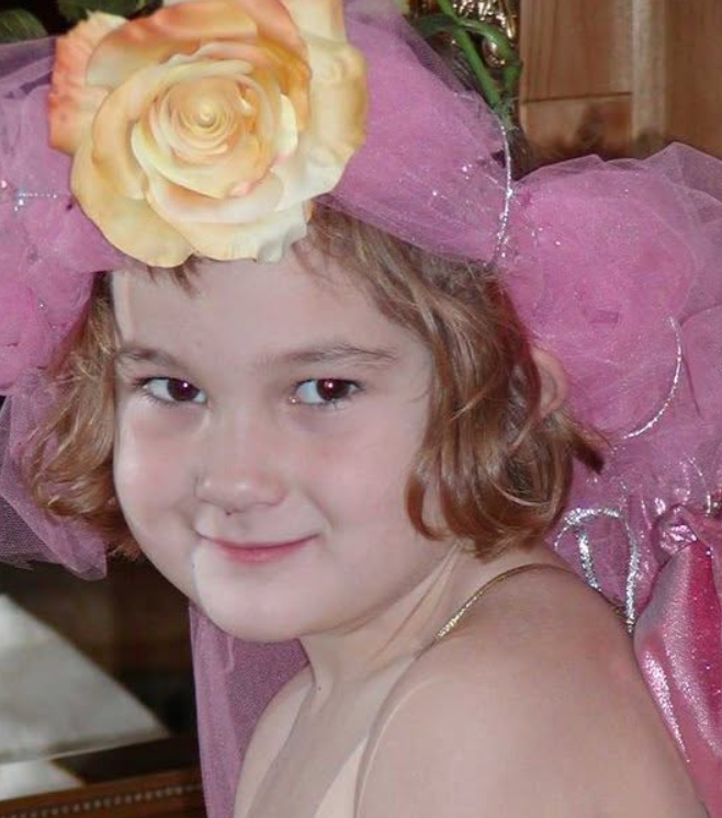 Haile as a young girl wearing a pink dress and rose headpiece