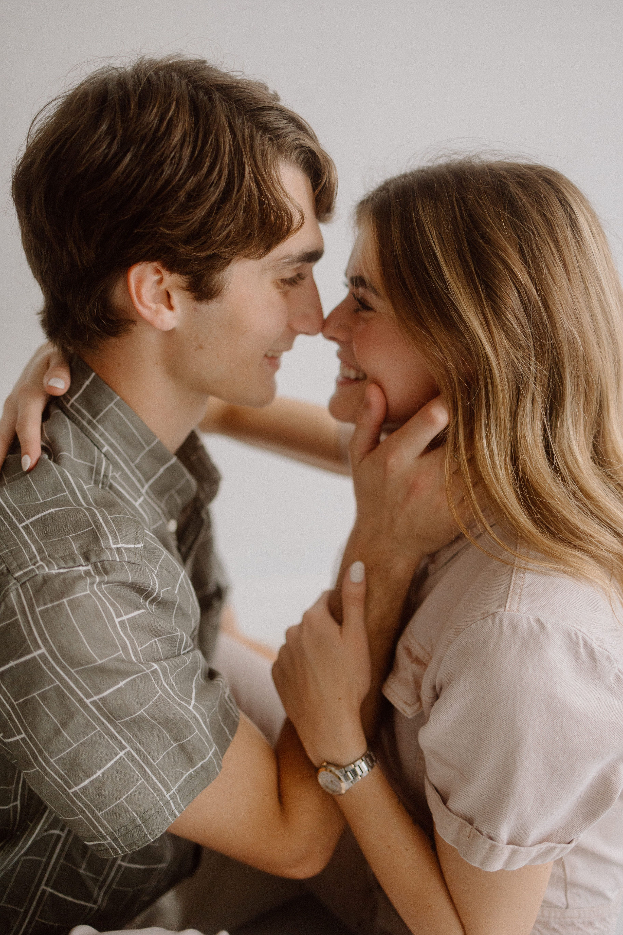 A couple pausing forehead to forehead, quietly noticing each other in soft daylight.