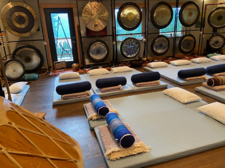 A Lifeshift Seminars healing room with gongs, meditation mats, and bolsters